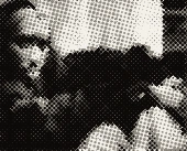 Tupac sitting in dark clothes, arms resting on his knees.